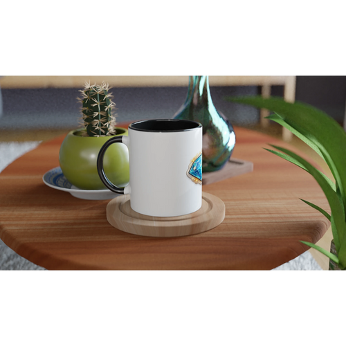 White mug with black interior on a wooden coaster on a table with decorative items.