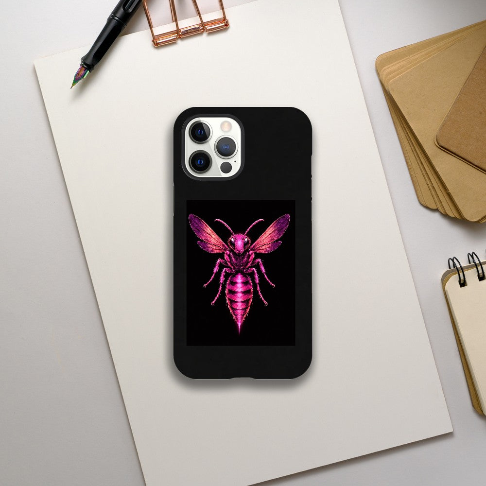 Phone case with a pink bee design on a black background, placed on a white surface with stationery items.