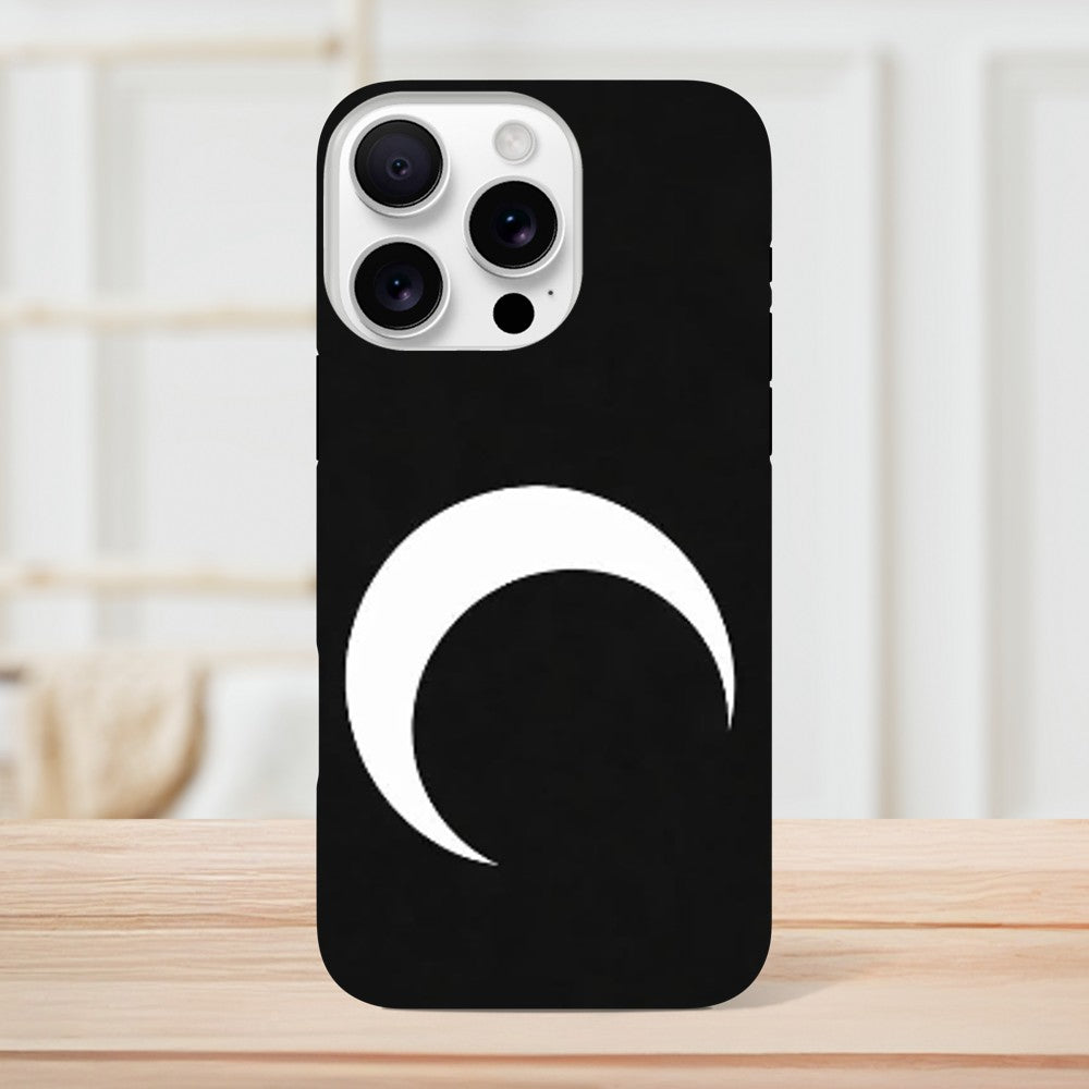 Black phone case with a white crescent moon design on a wooden surface.