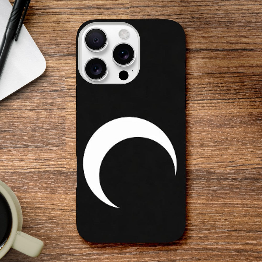 Black phone case with a white crescent moon design on a wooden surface.