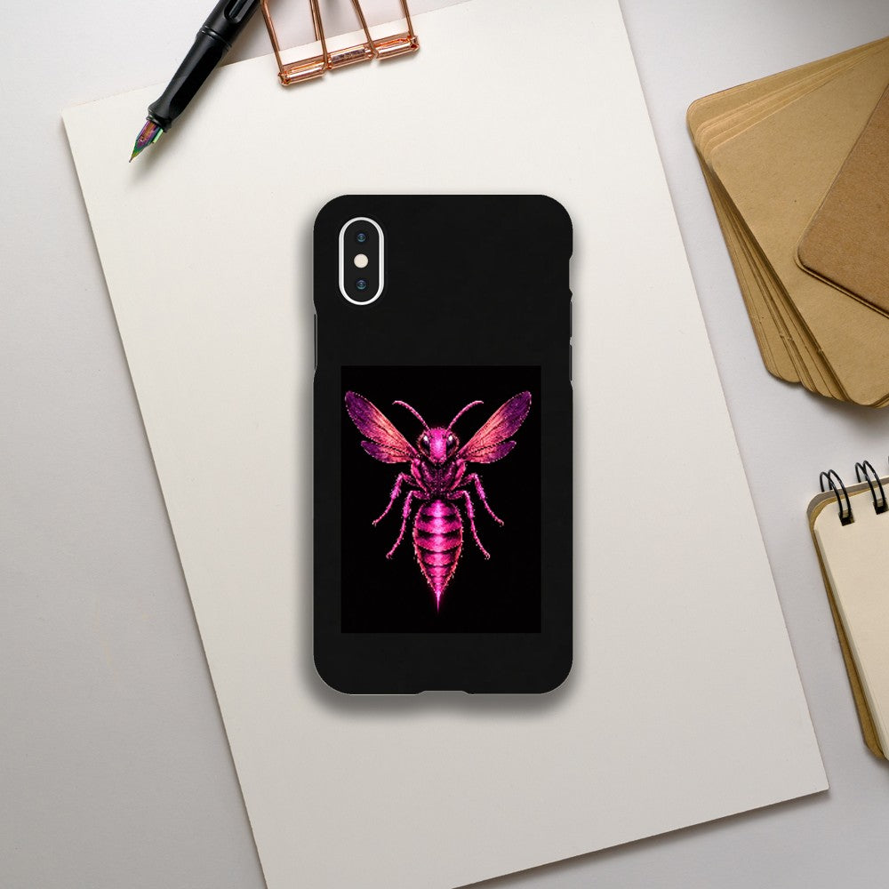 Phone case with a pink and purple insect design on a black background, placed on a white surface with stationery items.