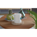 White mug on a wooden table with a cactus and decorative items.