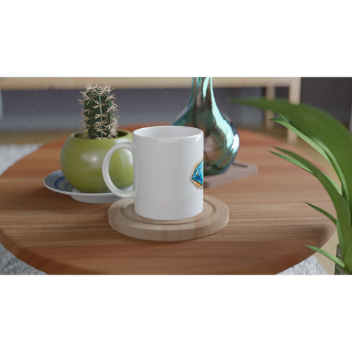 White mug on a wooden table with a cactus and decorative items.