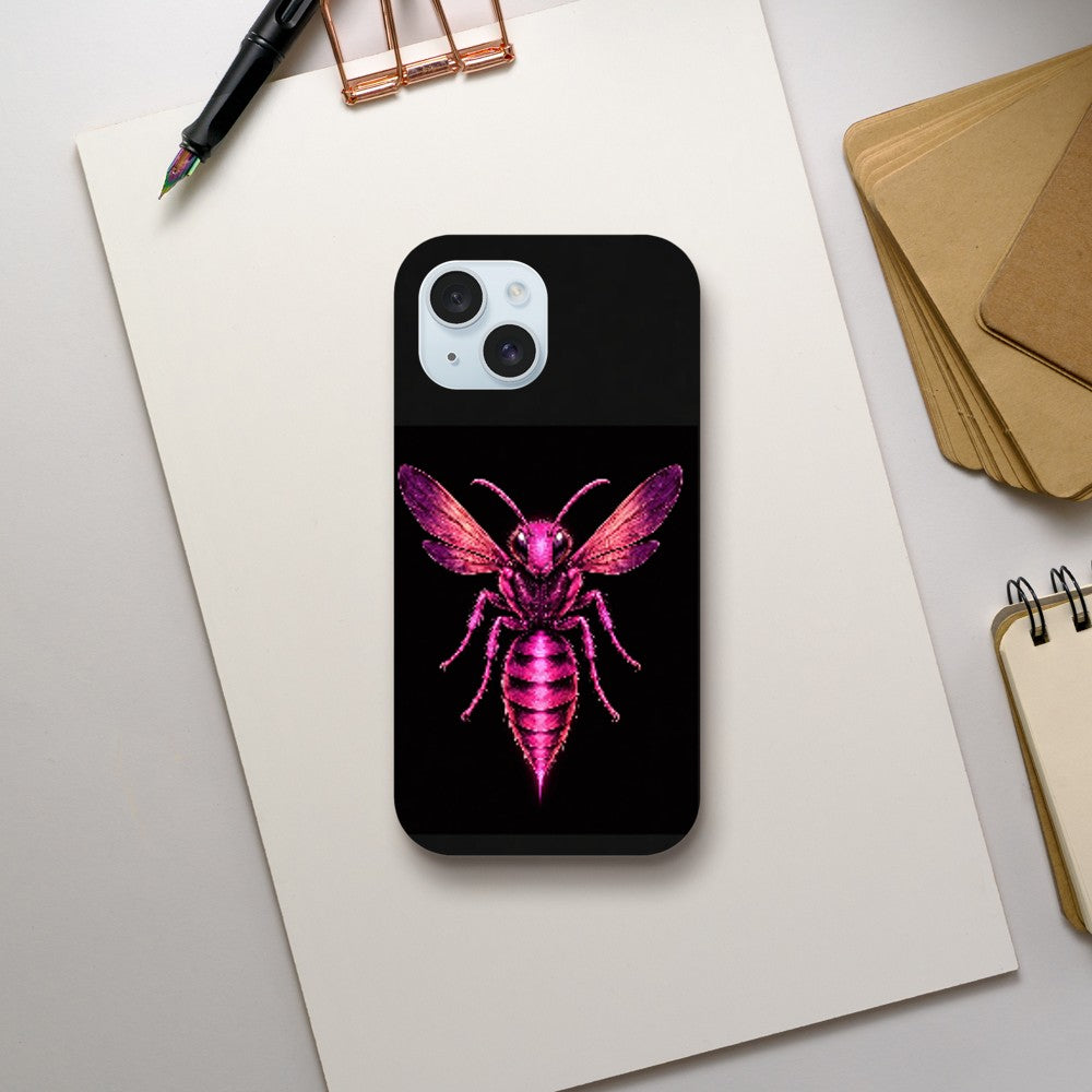 Phone case with pink bee design on a black background, placed on a light gray surface with stationery items.